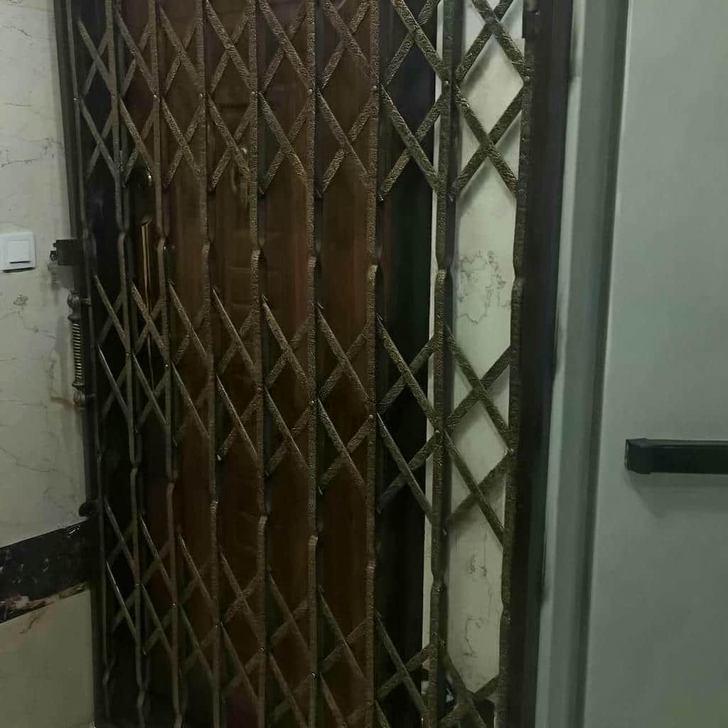 درب و حفاظ آکاردئونی نصب‌شده روی دیوار