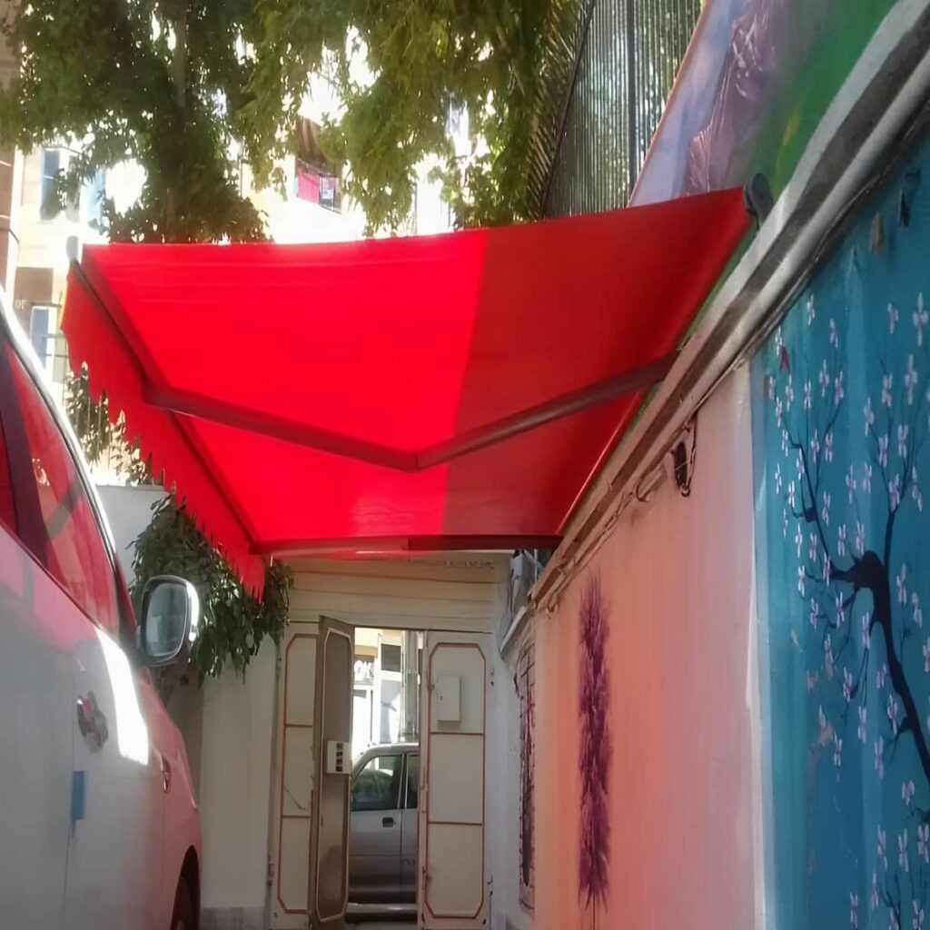 سایبان بازویی جمع شده بالای پنجره مسکونی