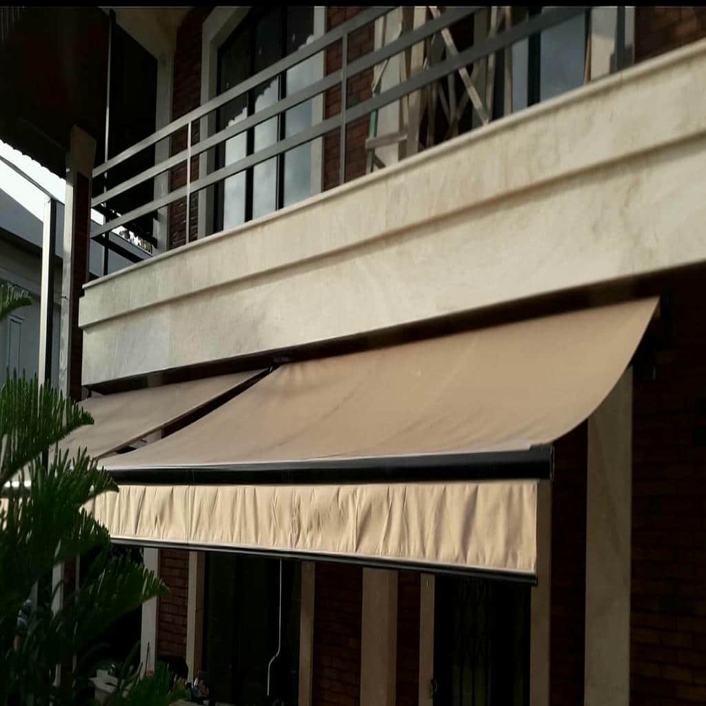 سایبان تاشو جمع شده کنار دیوار باریک
