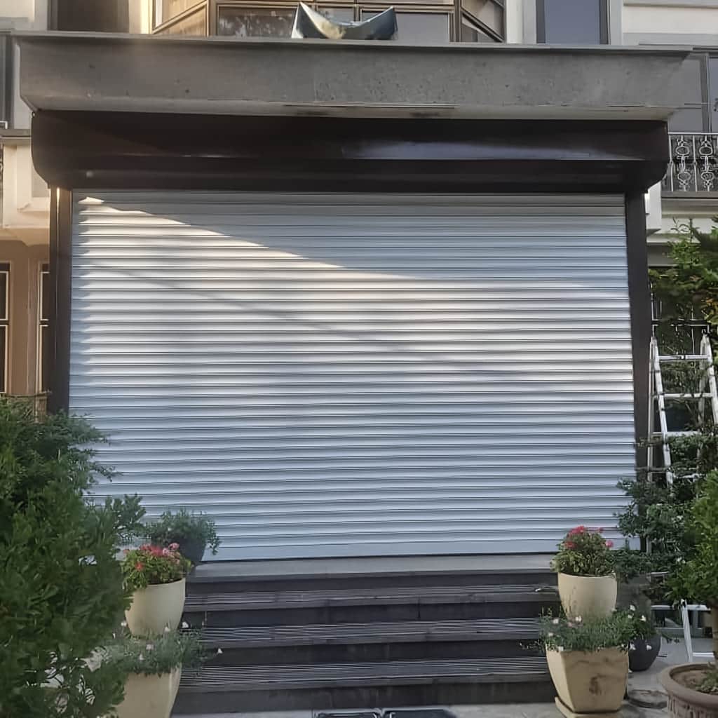 حفاظ ضربدری آکاردئونی باز شده کنار ورودی قدیمی